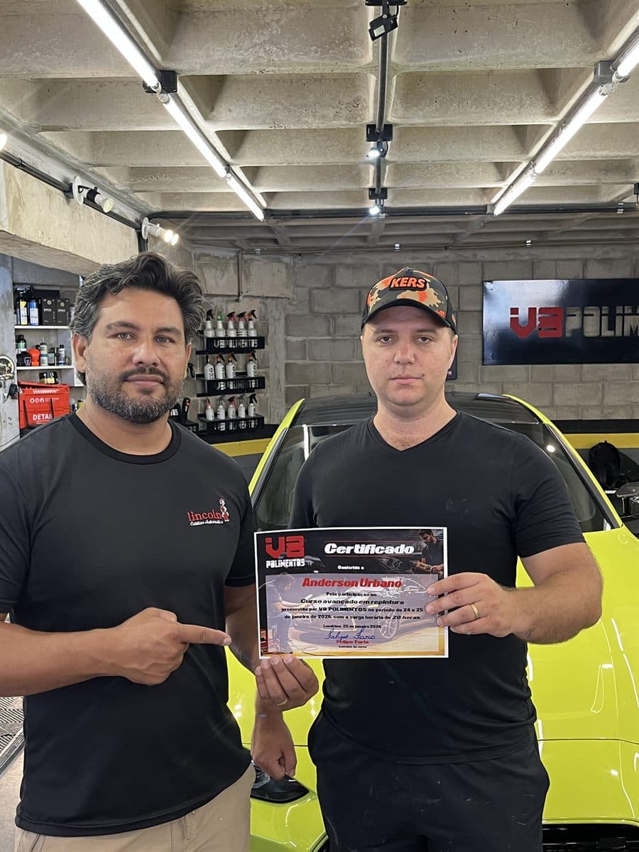 Aluno certificado ao lado do carro do treino