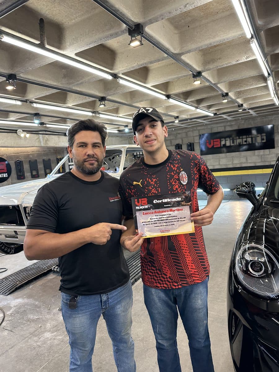 Aluno com certificado ao lado do veículo trabalhado